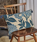 Decorative pillow with blue floral pattern on a wooden chair
